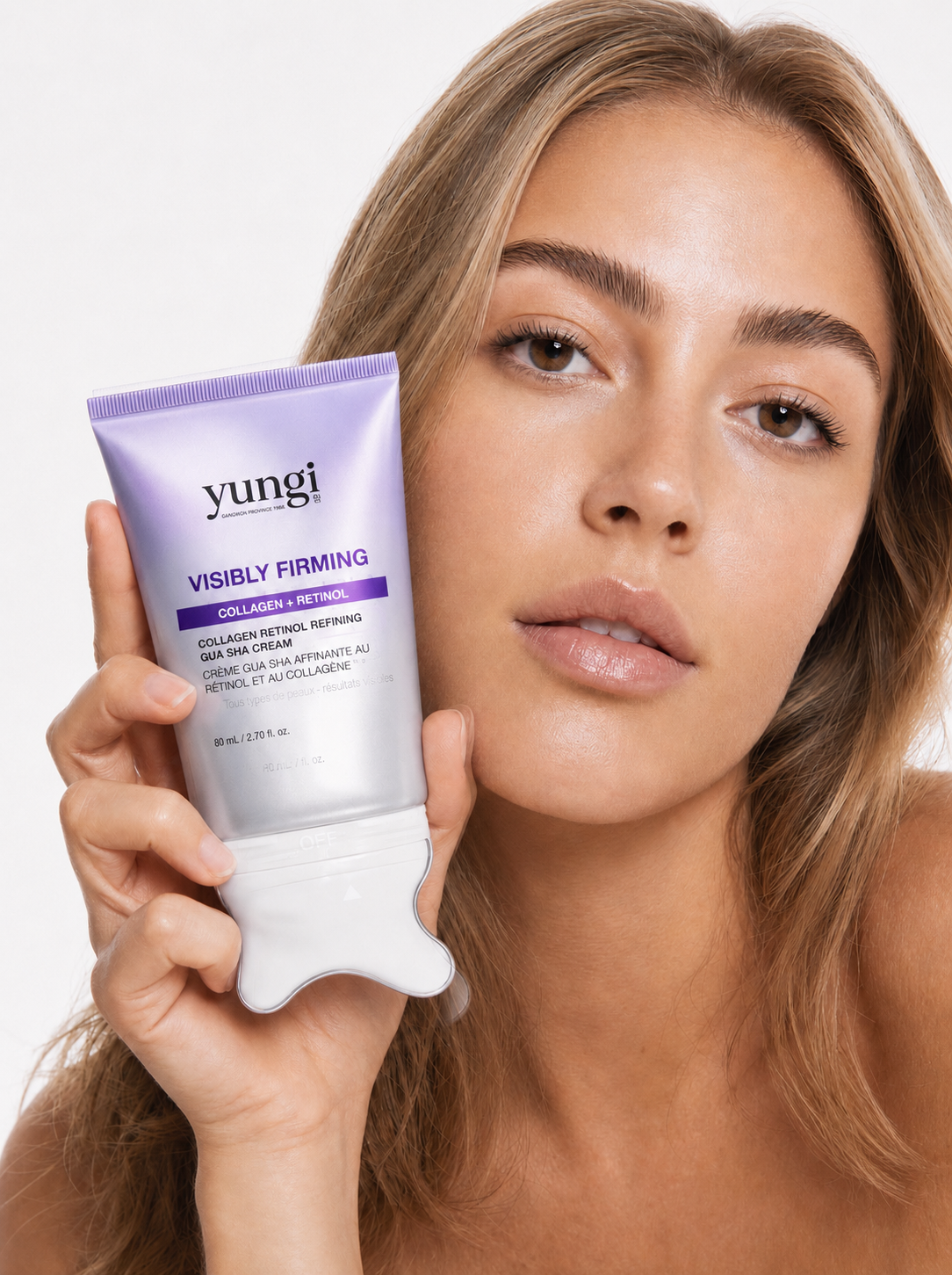 Femme tenant la crème gua sha yungi